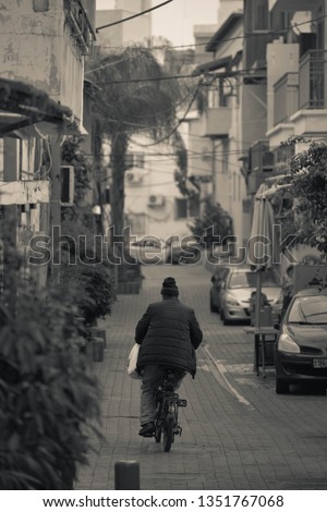 Man ridding a motorcycle down a quiet side street  