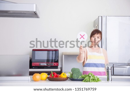 The woman who is in the kitchen