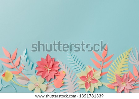 Paper craft origami fower decoration creative idea. tropical Flowers and leaves on blue pastel background, summertime, evegreen modern trendy concept



