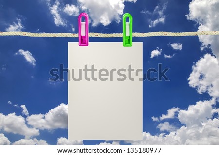 Blank paper on a clothes line against the blue sky