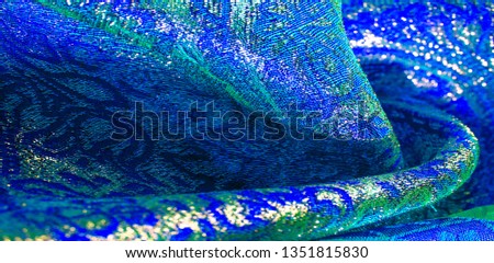 Texture background, pattern. blue brocade fabric. Organza brocade fabric - shepherd, with a crunchy palm. It has a large yarn-dyed flower embroidered pattern throughout.