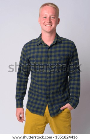 Portrait of happy young blonde hipster man smiling