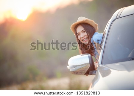 Asian women travel relax. Relaxed happy woman on summer roadtrip travel vacation leaning out car window. Happy beautiful girl traveling in a car