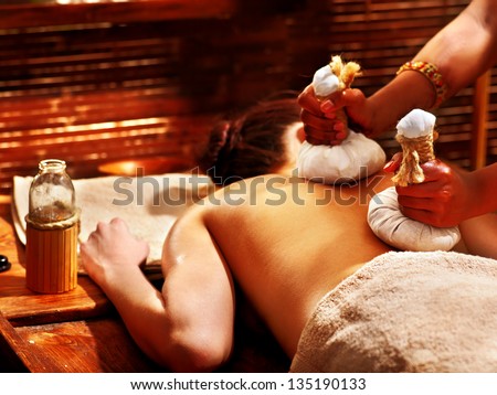 Woman having Ayurveda massage with herbal ball. Royalty-Free Stock Photo #135190133