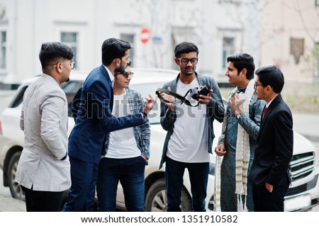 Group of six south asian indian mans in traditional, casual and business wear. Asia tourists looking at the dslr photo camera.