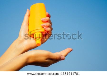 Bottle of sunscreen lotion suncream packaging on the sandy beach sea sky background copy space.oil spa spf summer vacation on tropical paradise copyspace