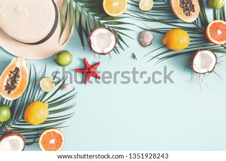Summer composition. Tropical palm leaves, hat, fruits on pastel blue background. Summer concept. Flat lay, top view, copy space
