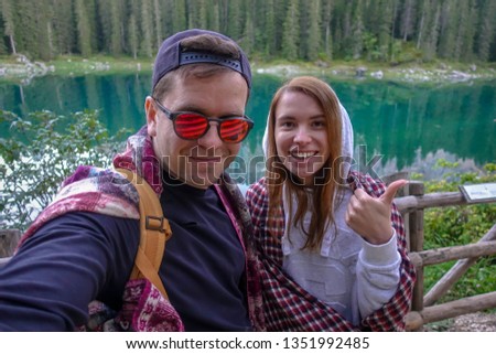 Young travelers couple making selfie near Carezza lake, Karersee, Dolomites, South Tyrol, Italy