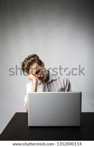 Young man using a laptop to browse the net. Overtime and fatigue concept.
