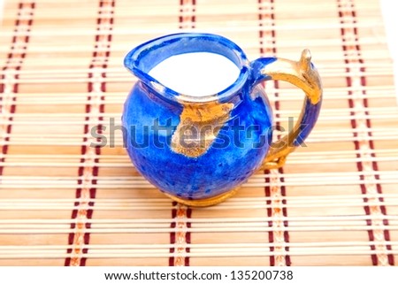 Blue milk jar on the straw kitchen mat