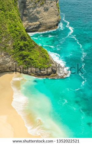 Lonely sand beach with rocks and turquoise blue sea water