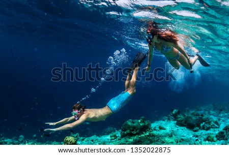 Young couple snorkeling and do skin diving on the coral reef edge in tropical waters of the Maldives Royalty-Free Stock Photo #1352022875