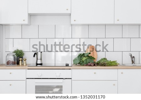 Scandinavian kitchen interior with simple cupboards and white tiles Royalty-Free Stock Photo #1352031170