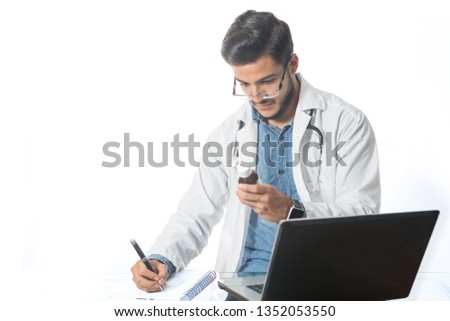Young doctor on his desk making a prescription