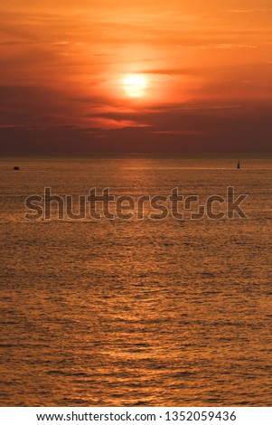 Sunset is reflected on the surface of the water. Black Sea. Waves on the surface of the sea. The texture of the water. Sunset in a cloudy sky.