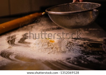 The chef hands mixes the dough from flour and eggs. Smoke flour. Kitchen processes.