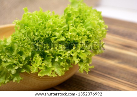 Fresh organic green lettuce salad leaves in wooden bowl Healthy food concept