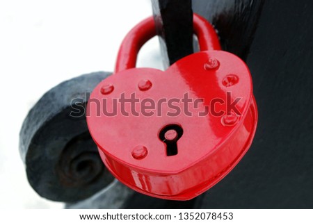 Red iron lock on the bridge support as a sign of the eternal love of two people