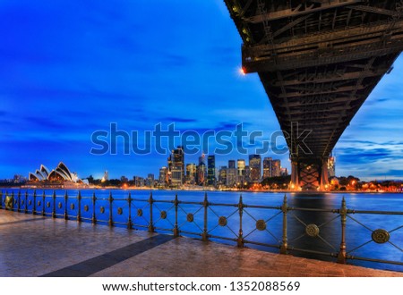 Major Sydney city CBD landmarks - Harbour Bridge, Circular Quay and CBD skyscrapers at sunset across harbour from Milsons Point. Royalty-Free Stock Photo #1352088569