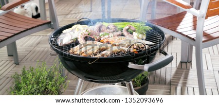 Grilled fresh seafood: prawns, fish, octopus, oysters food background Barbecue / Cooking BBQ seafood on fire