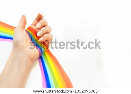 Rainbow in hand with unicorns manicure. White background with empty space