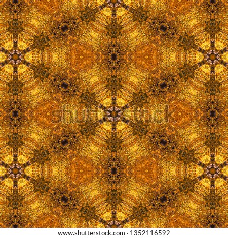 Kaleidoscope effect of a picture of fall trees with golden autumn leaves creates an ornate hexagon pattern