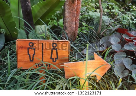 A classic and simple design handmade wooden sign of toilet, rest room in the garden showing direction to WC. The universal sign.