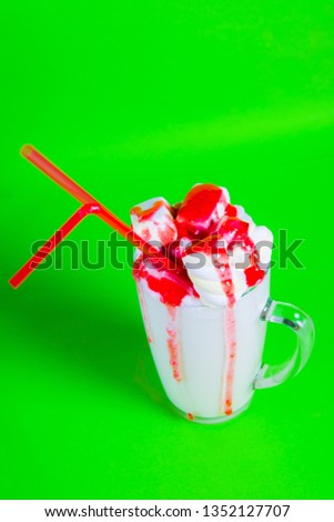 milkshake with a straw and marshmallows on a green background