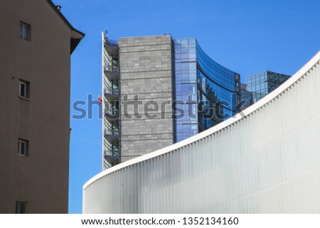 Workers in bright orange uniform working on a modern building facade, business concept photography
