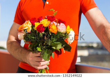 man holding a bouquet of flowers. colorful bright roses.