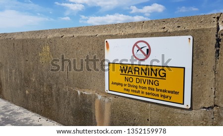 No diving sign on sea defence wall.