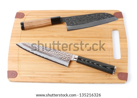 Two top grade japanese knives on bamboo cutting board, isolated