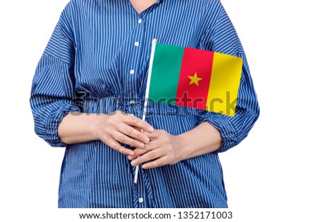 Cameroon flag. Close up of woman's hands holding a national flag of Cameroon isolated on white background.