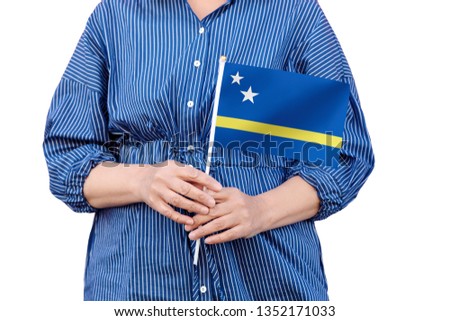 Curaçao flag. Close up of woman's hands holding a national flag of Curacao isolated on white background.