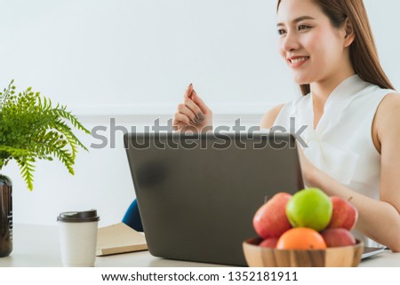 smart executive asian woman white dress meeting with coworker with laptop presentation office background