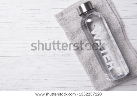 Bottle of water with word water on it on the grey towel, healthy life concept