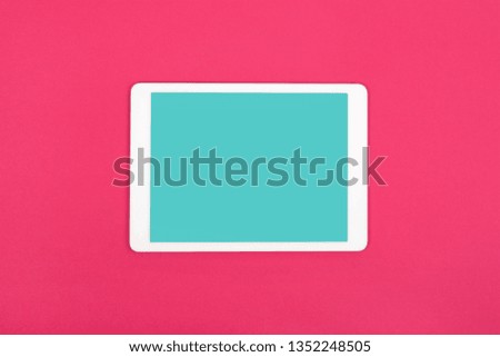 Flat lay of white touchpad with blank touchscreen on red background