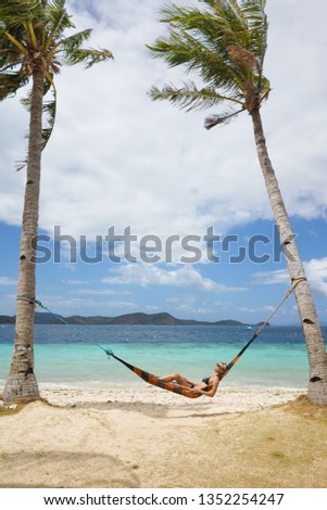 Woman relaxing at the beach on a hammock Travel and vacation concept.