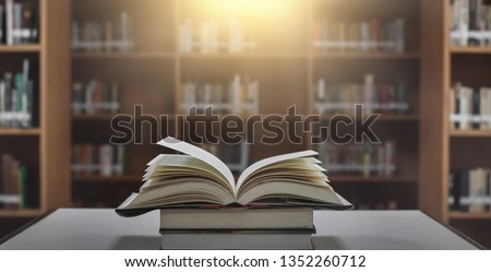 Stack of books in the library and blur bookshelf background Royalty-Free Stock Photo #1352260712