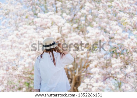 spring season with full bloom pink flower travel concept from beauty asian woman enjoy and see to cherry blossom with soft focus flower background