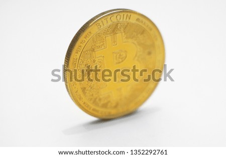 Physical version of golden bitcoin on white background.