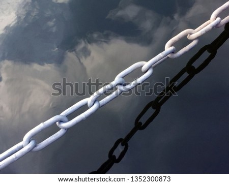White metal chain and reflection on water surface