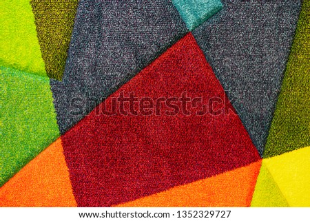 Texture of a multi-colored carpet. Background of the carpet with multi-colored inserts.