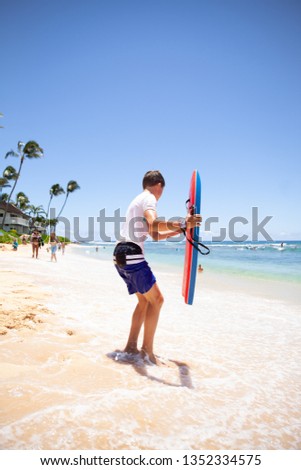 One boy with a bodyboard at the beach in Kauai, Hawaii