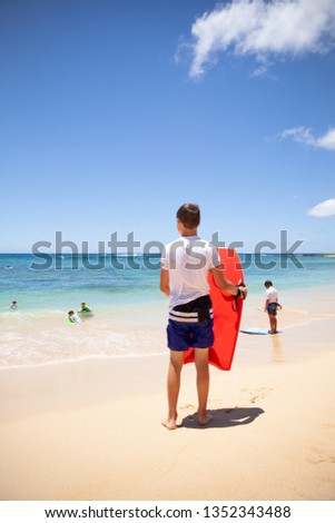 One boy with a bodyboard at the beach in Kauai, Hawaii