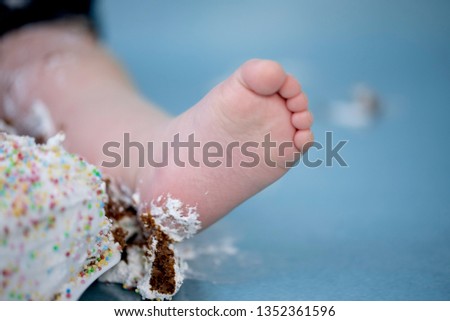The foot of a baby in a cake at the photo shoot Smash the Cake