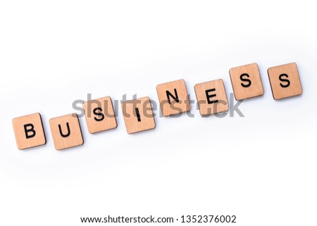 The word BUSINESS, spelt with wooden letter tiles over a white background.