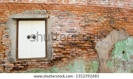 Ancient brick wall An old house Beautiful broken brick pattern Ancient windows that still compete