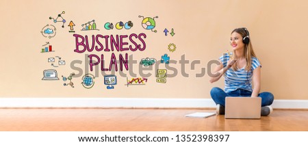 Business plan with young woman with headphones using a laptop computer and a pencil