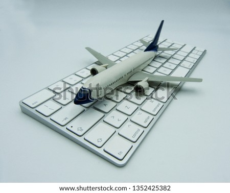 White airplane on a white computer keyboard. Aviation concept.

